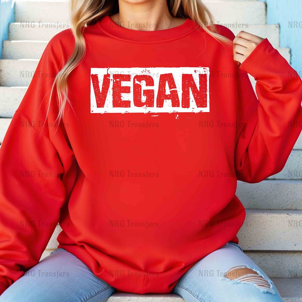 a woman wearing a red sweatshirt with the word vegan printed on it