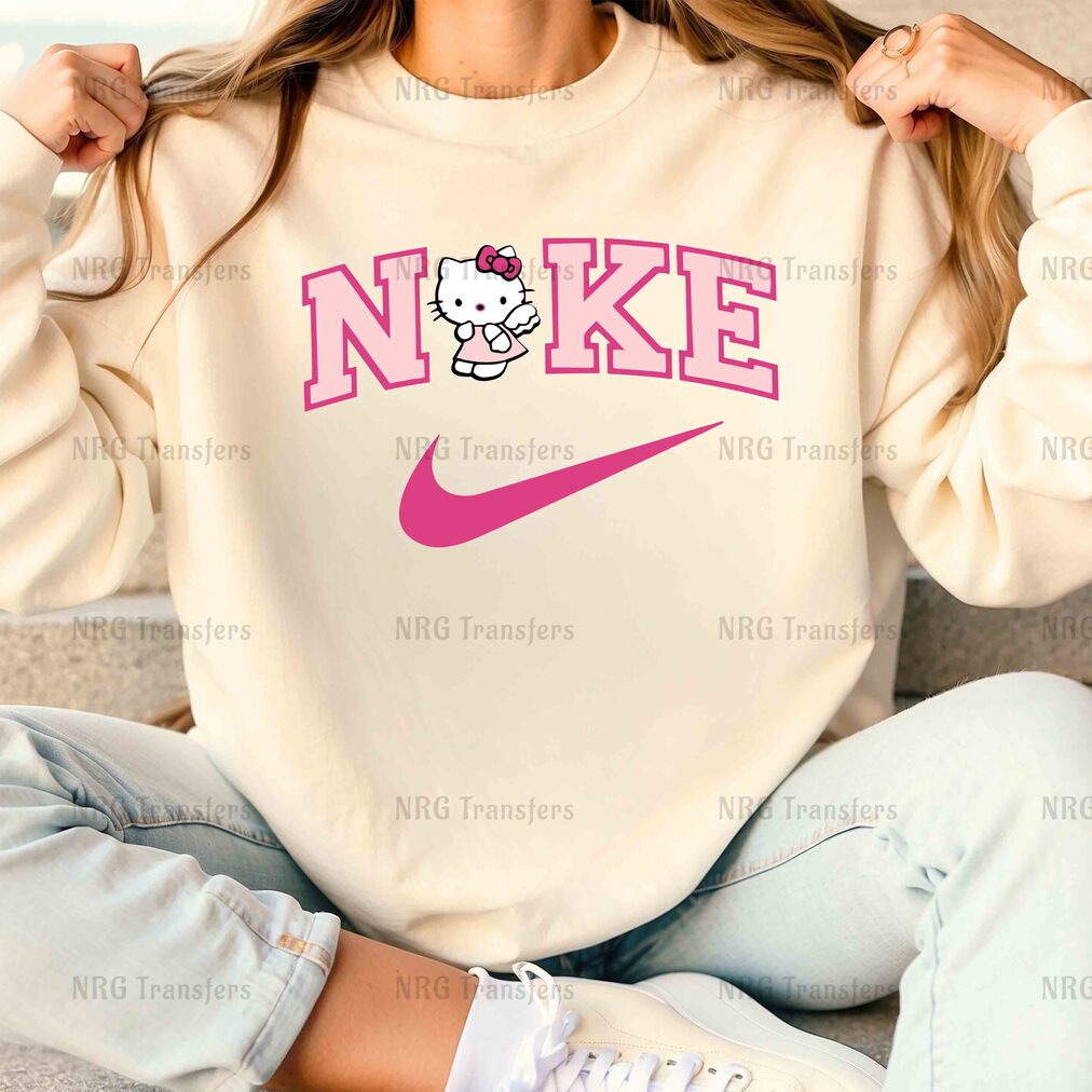 a woman sitting on a couch wearing a sweatshirt with a hello kitty on it