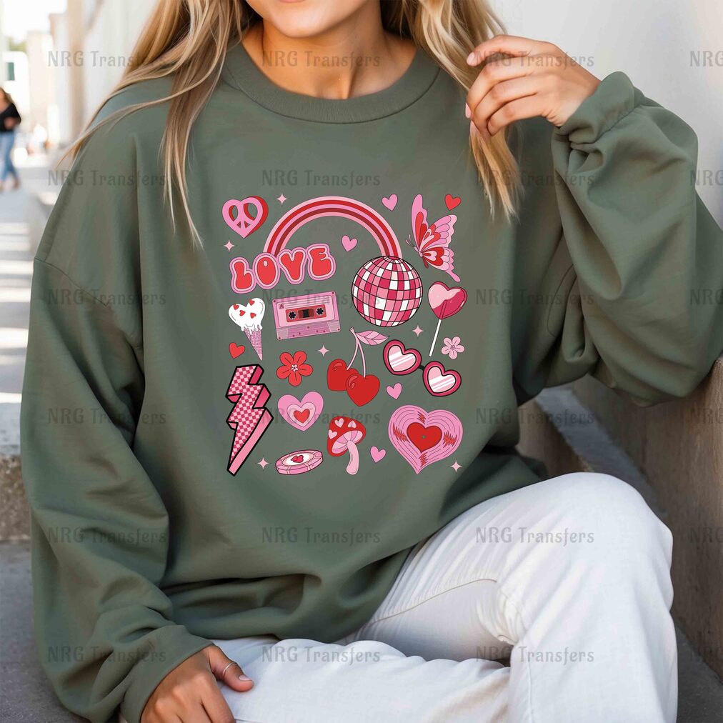 a woman sitting on the ground wearing a green sweatshirt