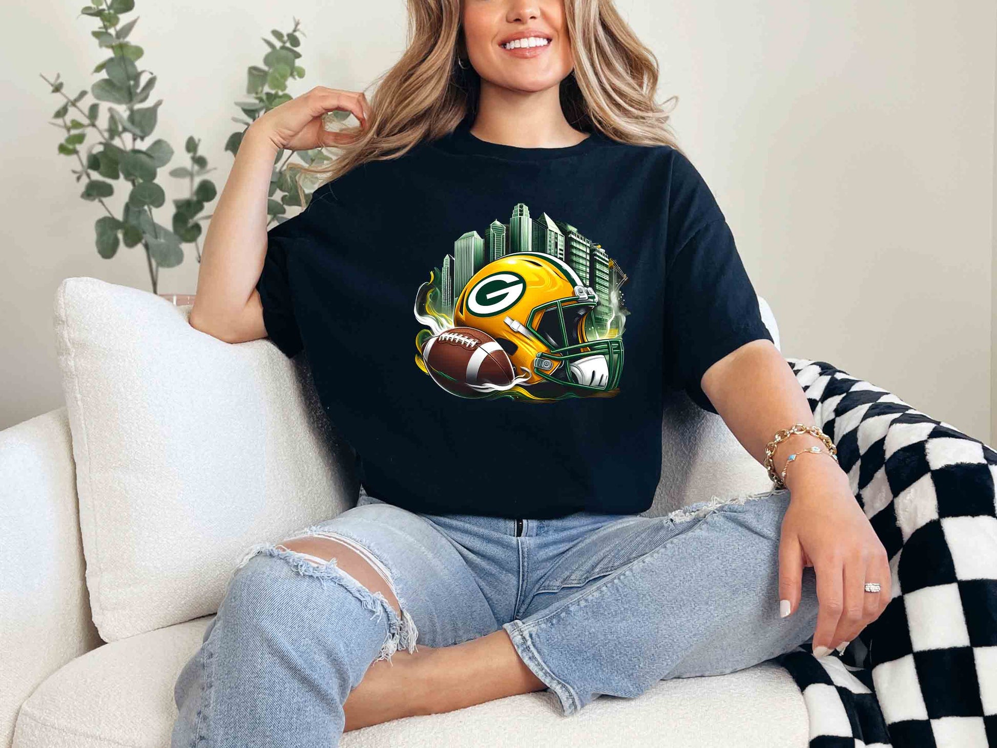 a woman sitting on a couch wearing a green bay packers t - shirt