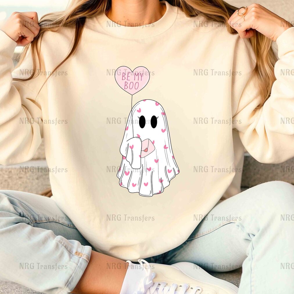 a woman sitting on a couch wearing a sweatshirt with an elephant holding a heart balloon