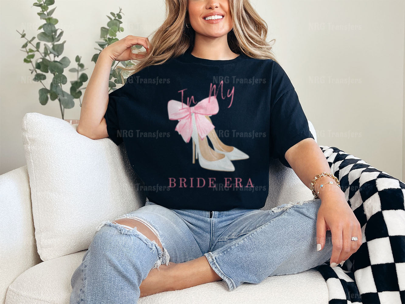 a woman sitting on a couch wearing a t - shirt with a pink bow